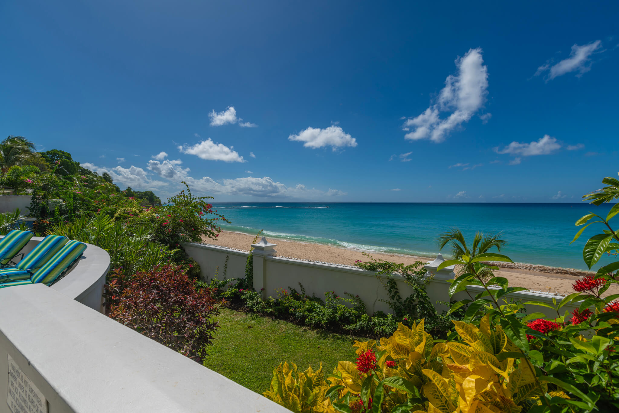 Perfect beach view from the poolside with a lush garden in-between the two spaces