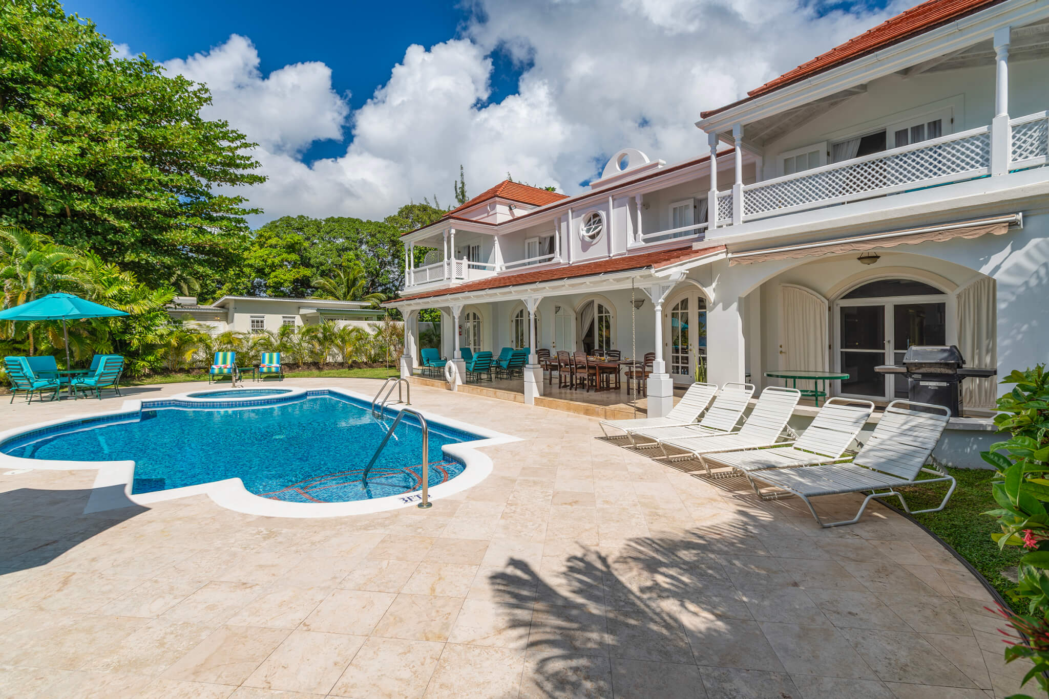 Poolside with views onto the house with five white sunbeams by the pool